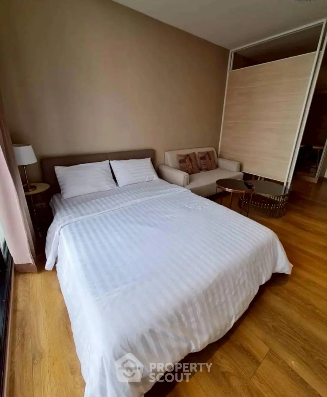 Cozy bedroom with wooden flooring and elegant decor in modern apartment