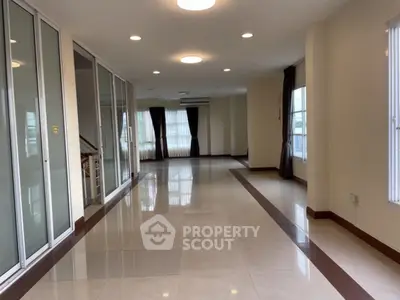 Spacious modern living room with large windows and elegant tile flooring