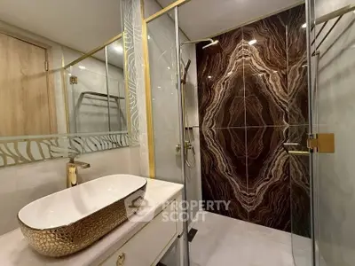 Luxurious bathroom with elegant gold fixtures and stunning marble accent wall