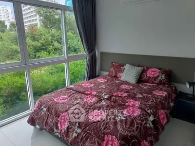 Cozy bedroom with large window offering lush green view in modern apartment