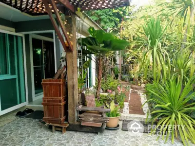 Charming garden entrance with lush greenery and cozy seating area