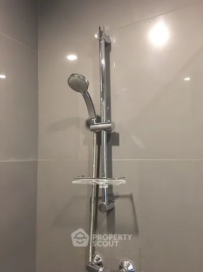 Modern bathroom shower with sleek chrome fixtures and elegant tile design.