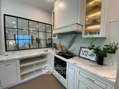 Modern kitchen with elegant cabinetry and open layout, featuring a sleek marble countertop and stylish decor.