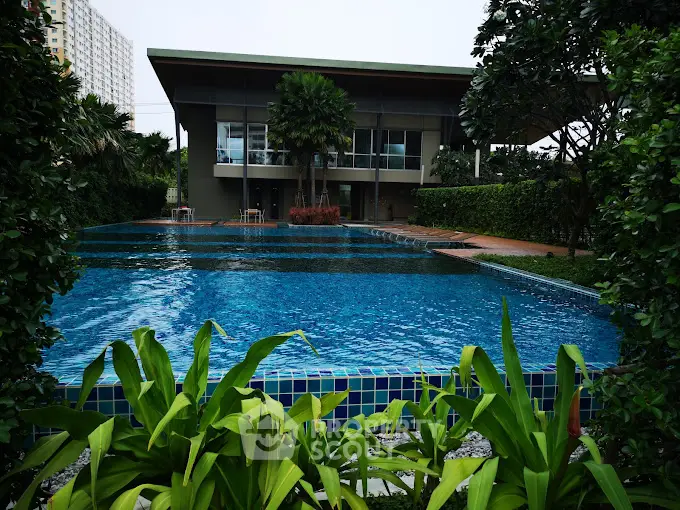 Luxurious residential pool with lush greenery and modern architecture.