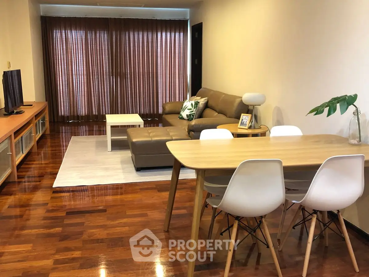 Modern living room with wooden floors, stylish furniture, and natural light.