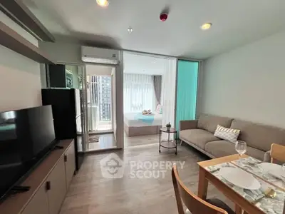 Modern open-plan living room with cozy sofa and dining area, leading to a bright bedroom.