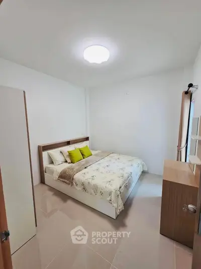 Cozy bedroom with modern decor and ample natural light, perfect for relaxation.