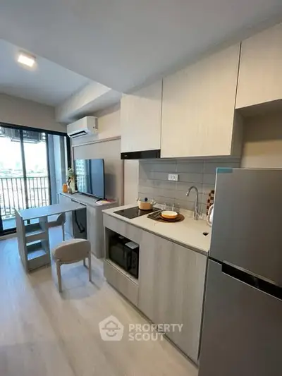 Modern kitchen with sleek cabinetry and integrated appliances in a bright apartment.