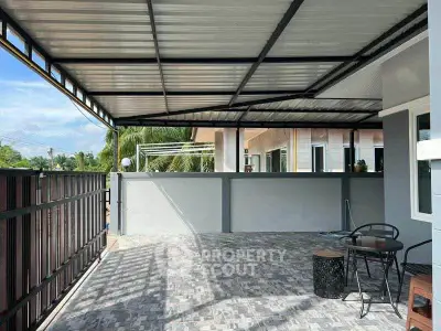 Spacious covered patio with modern seating and tiled flooring, perfect for outdoor relaxation.