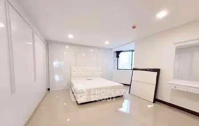 Spacious modern bedroom with elegant white decor and large windows