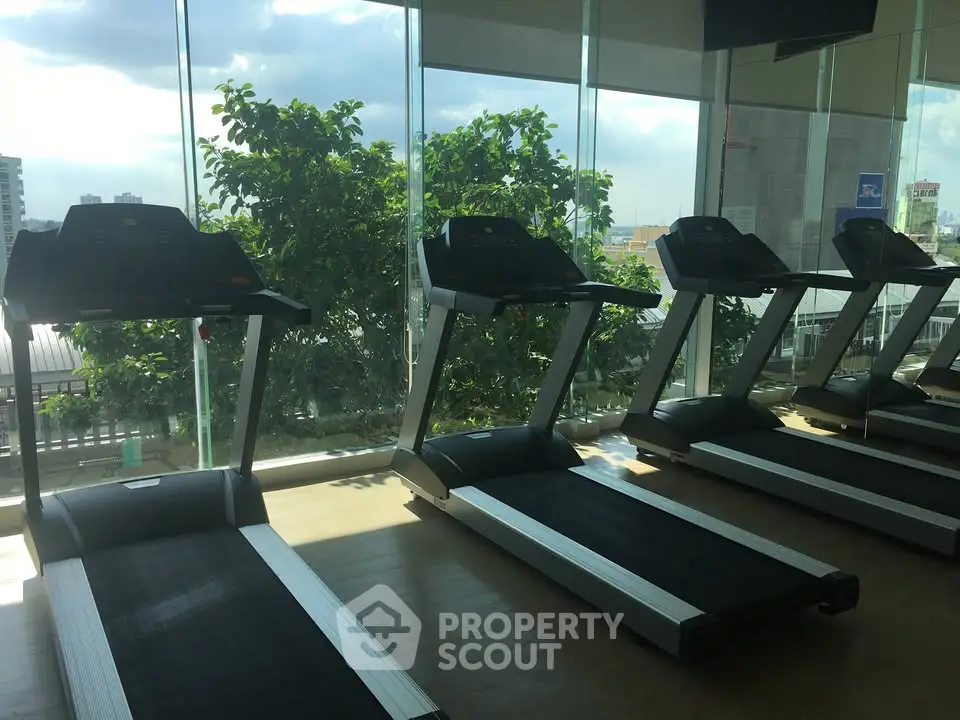 Modern gym with treadmills and large windows offering city views