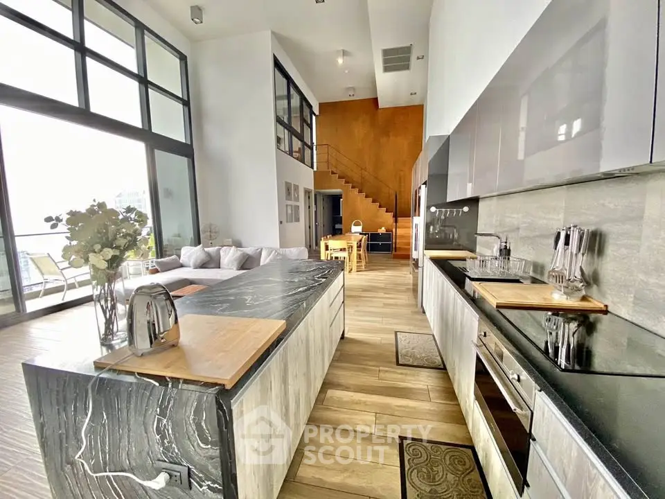 Luxurious modern kitchen with open layout and high ceilings, featuring sleek appliances and elegant design.