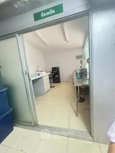 Industrial-style room with stainless steel counters and equipment, ideal for production or laboratory use.
