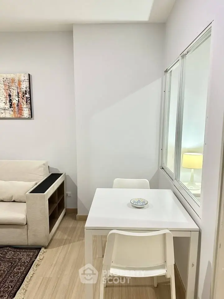 Modern living room with cozy sofa and dining area, featuring elegant decor and natural light.