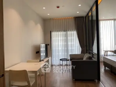 Modern studio apartment with open layout, featuring a cozy living area and natural light.