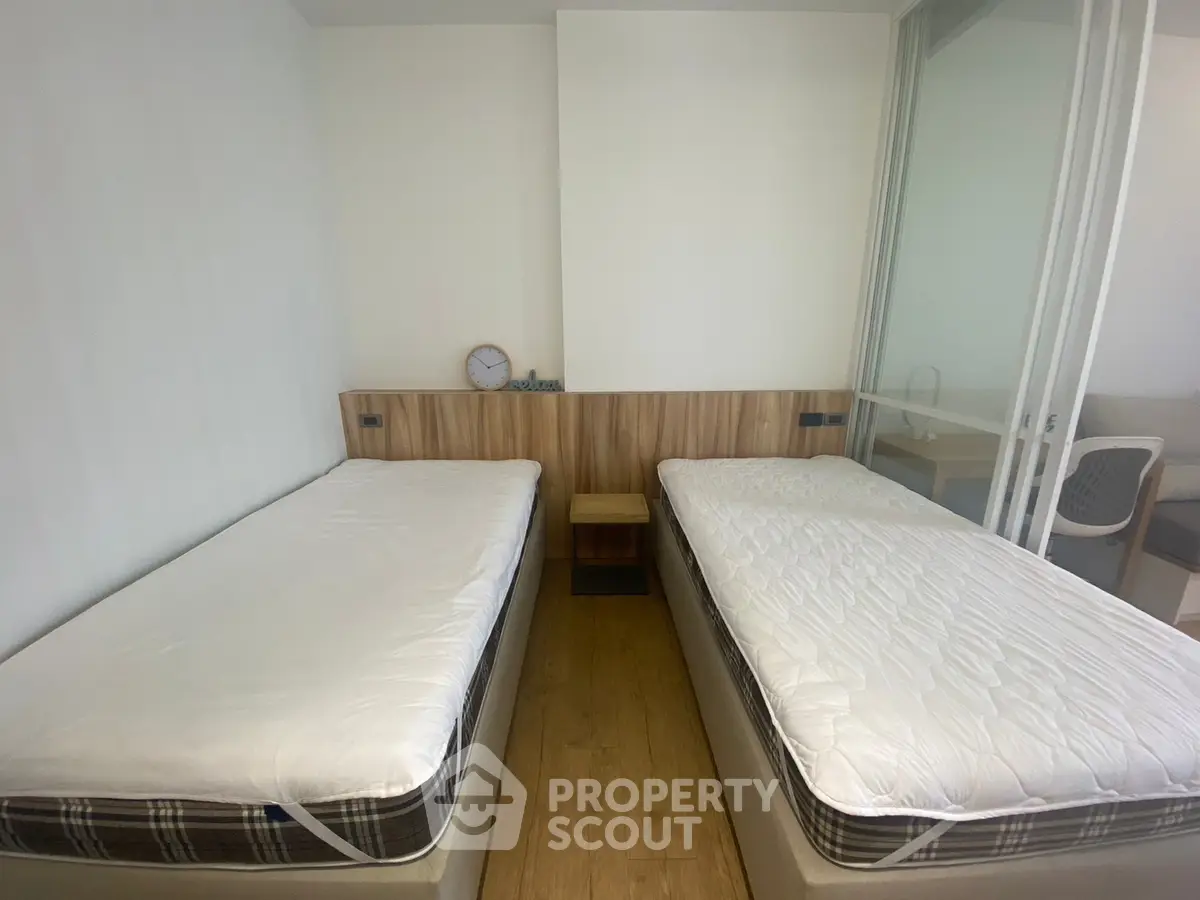 Modern twin bedroom with minimalist design and wooden flooring