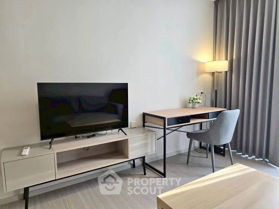 Modern living room with sleek TV stand and stylish desk setup, perfect for urban living.