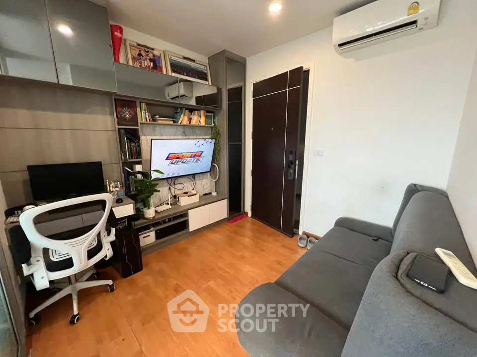 Modern living room with sleek furniture and built-in storage, featuring a cozy workspace and entertainment area.