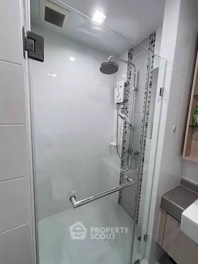 Modern bathroom with glass shower enclosure and sleek fixtures