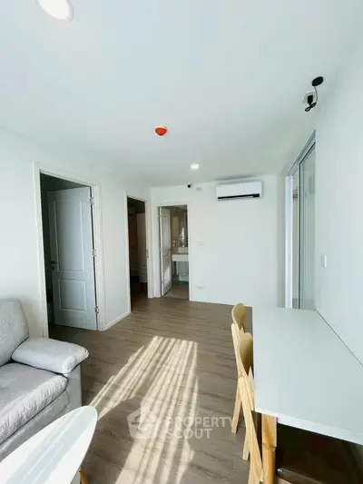 Bright modern living room with sleek furniture and large windows in a contemporary apartment.