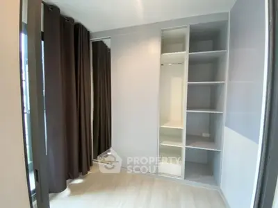 Spacious modern closet with mirrored sliding doors and ample shelving in a bright room.
