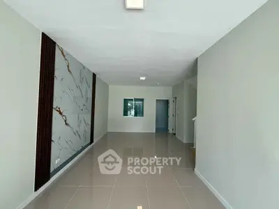 Spacious modern living room with elegant marble accent wall and glossy tiled flooring.
