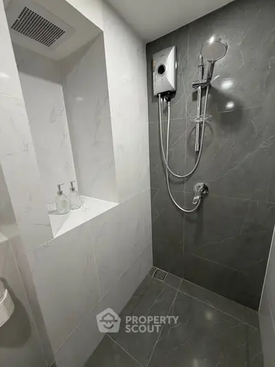 Modern bathroom with sleek gray tiles and built-in shower niche