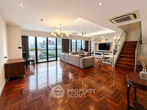 Luxurious open-plan living room with stunning city views and elegant wooden flooring.