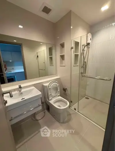 Modern bathroom with glass shower and sleek fixtures in a contemporary apartment.