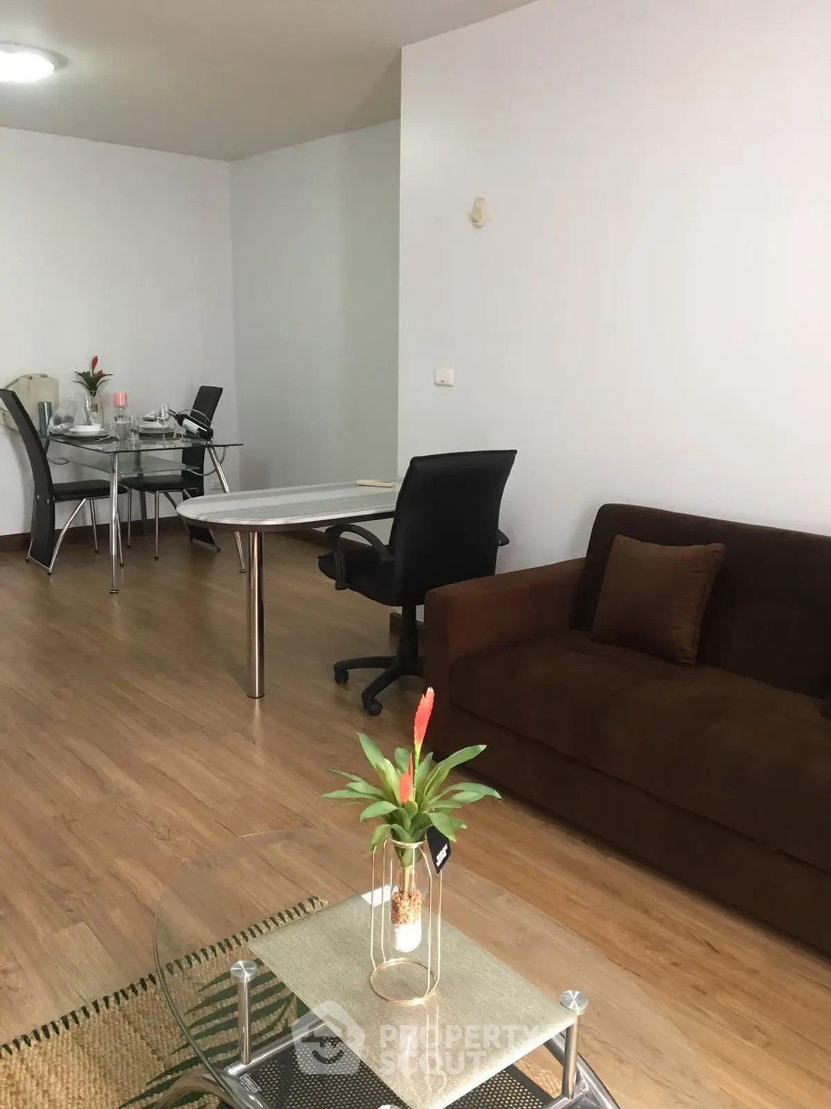 Modern living room with sleek furniture and wooden flooring, perfect for a cozy home office setup.