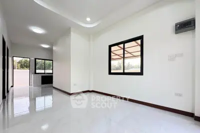 Spacious modern living room with large windows and glossy white tiles