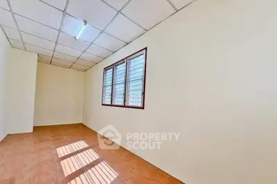 Spacious empty room with natural light and tiled flooring