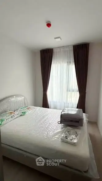 Cozy bedroom with natural light and modern furnishings, perfect for relaxation and comfort.
