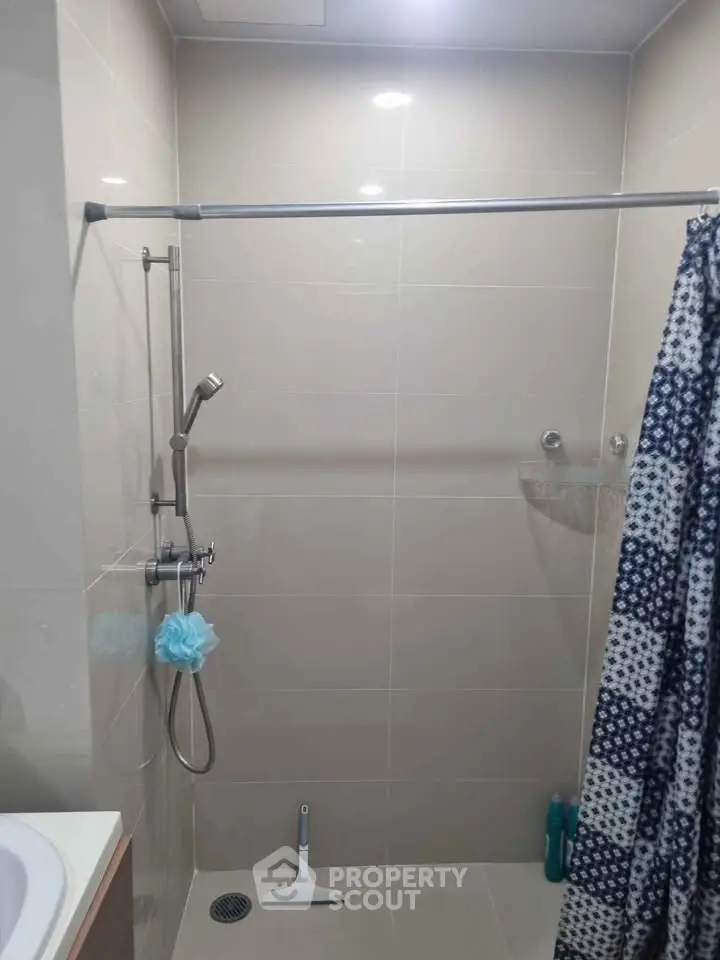 Modern bathroom with shower curtain and handheld showerhead