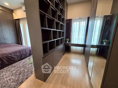 Modern bedroom with stylish shelving and large windows for natural light.