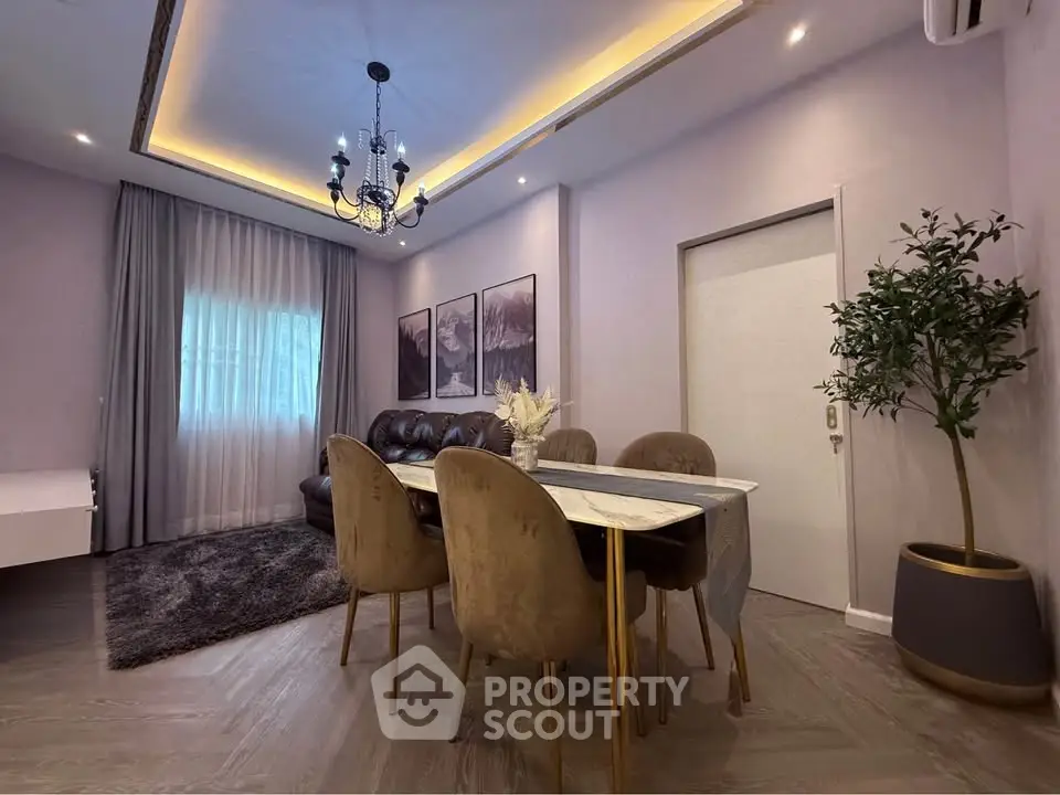 Elegant dining area with modern chandelier and cozy seating in a stylish apartment.