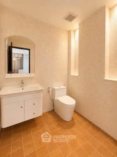 Modern bathroom with sleek fixtures and warm tile flooring