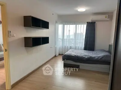 Spacious bedroom with modern shelving and city view from window.