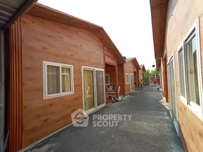 Charming wooden exterior of modern residential units with large windows and sliding doors.