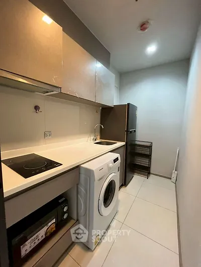 Modern compact kitchen with washing machine and sleek appliances