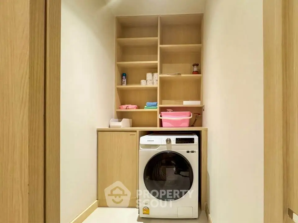 Modern laundry room with washing machine and wooden shelving