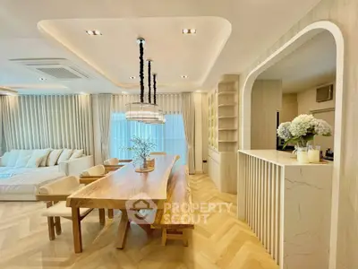 Luxurious open-plan living and dining area with elegant wooden table and modern lighting.