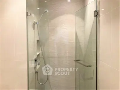 Modern bathroom with glass shower enclosure and sleek fixtures.