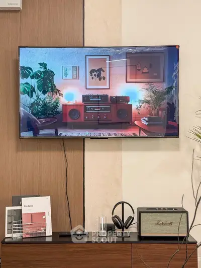 Stylish living room with modern decor, featuring a wall-mounted TV and sleek audio equipment.