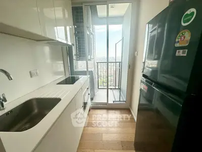 Modern compact kitchen with balcony view in high-rise apartment