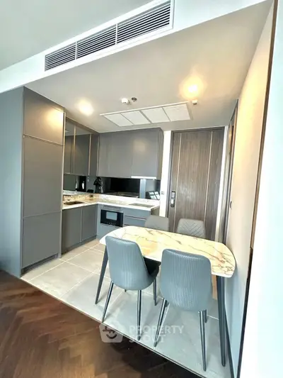 Modern kitchen with sleek cabinetry and dining area in stylish apartment