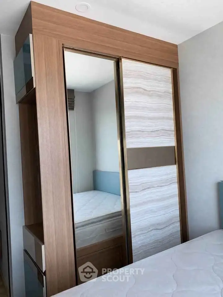 Modern bedroom with stylish wooden wardrobe and comfortable mattress.