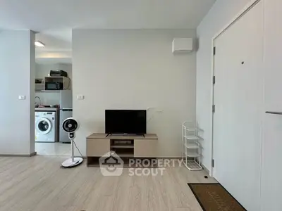 Modern living room with sleek TV stand and washing machine in open layout