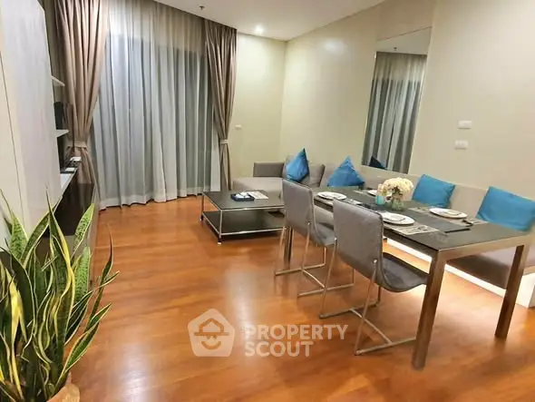 Modern living room with dining area, hardwood floors, and elegant decor