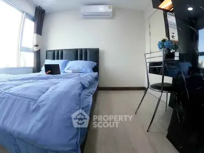 Modern bedroom with blue bedding, air conditioning, and sleek black furniture.